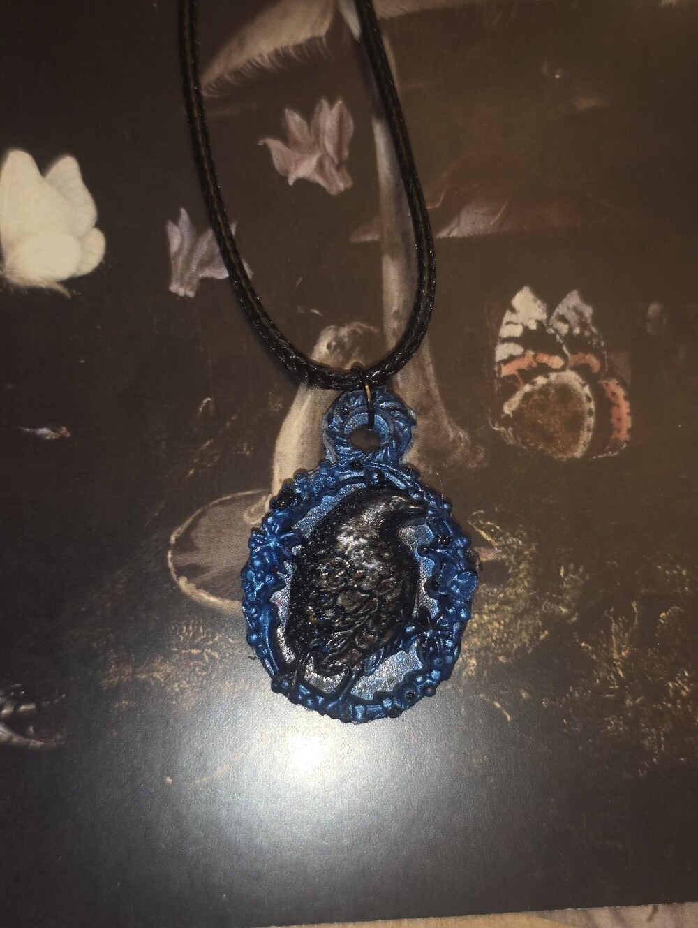 Black Raven In Blue Resin Frame Pendant On Black Cord Necklace